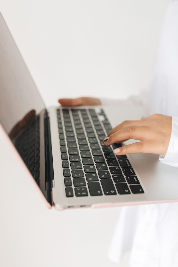 Close-up view of hands using a laptop keyboard. Ideal for tech and lifestyle themes.